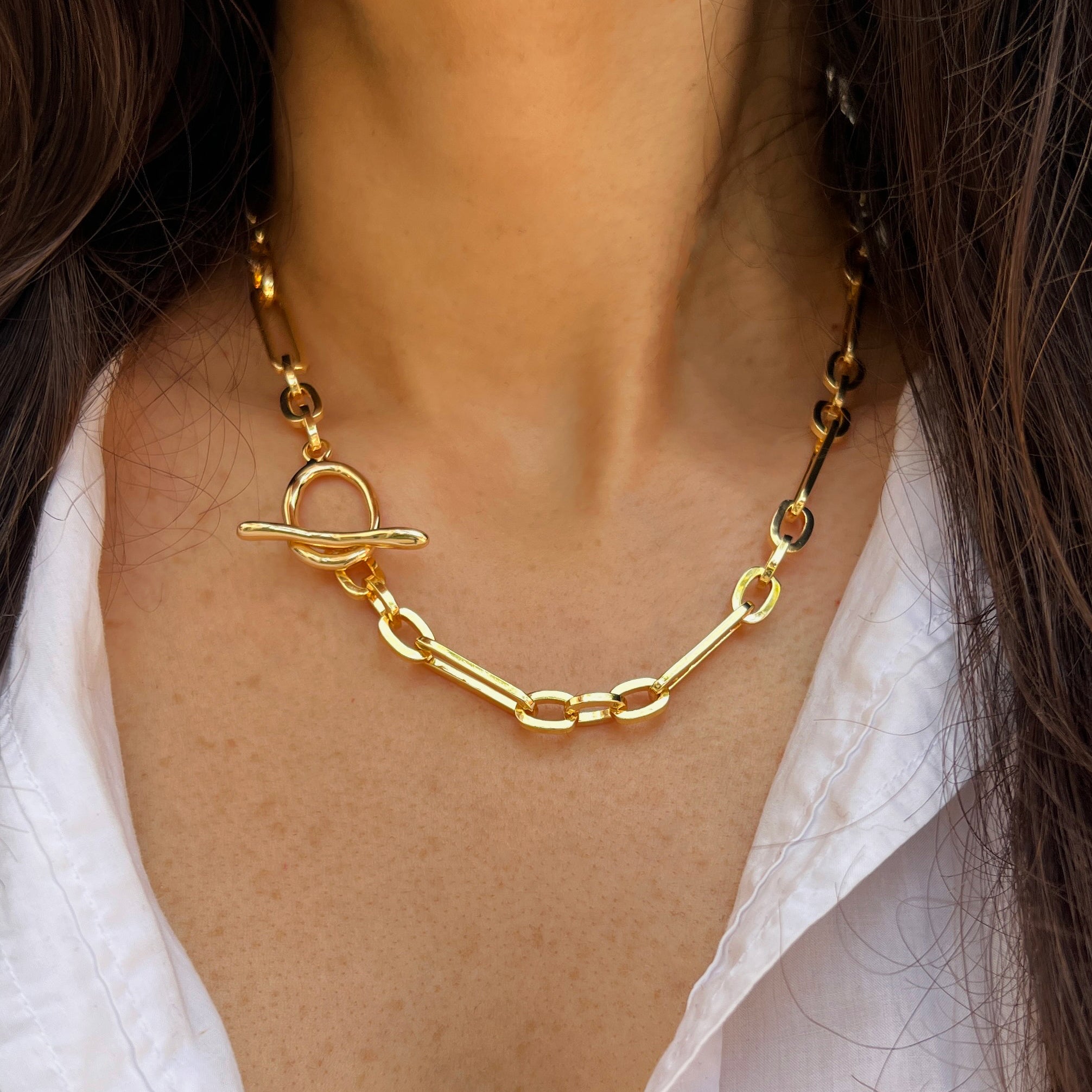 Gold chain necklace worn by a person with a blurred background
Mixed Link Toggle Chain Necklace
Yellow Gold Plated
Large link: 0.83" Long X 0.24" Wide
Small Circle link: 0.36" Long X 0.25" Wide
16" Long
