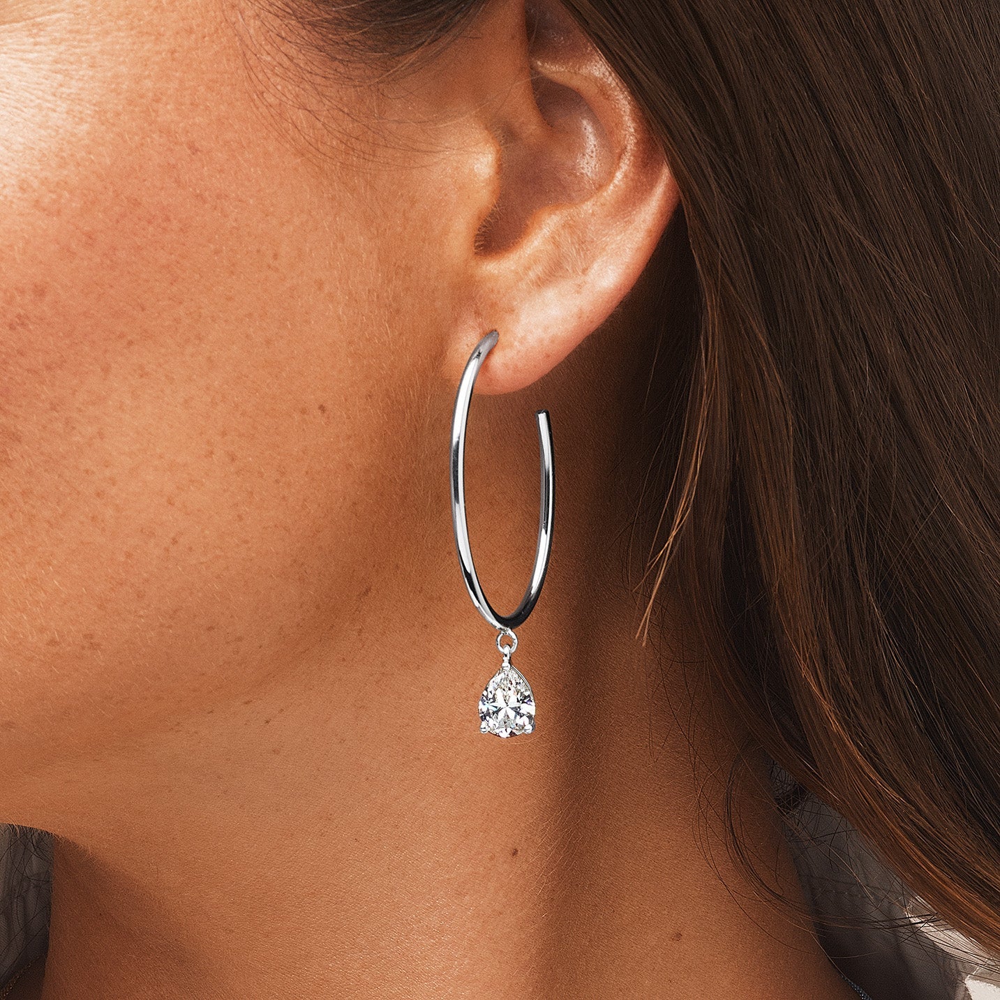 Oval Hoop Sparkle Drop Earrings 14K Yellow or White Gold Plated 2 High intensity Basket-set Pear Shaped CZs CZs approximately 1.5 cts each 2.25 Inches Long including the CZ Drop 1.5 Inches Long not including the CZ drop Pierced, post backings with oversized butterfly push back