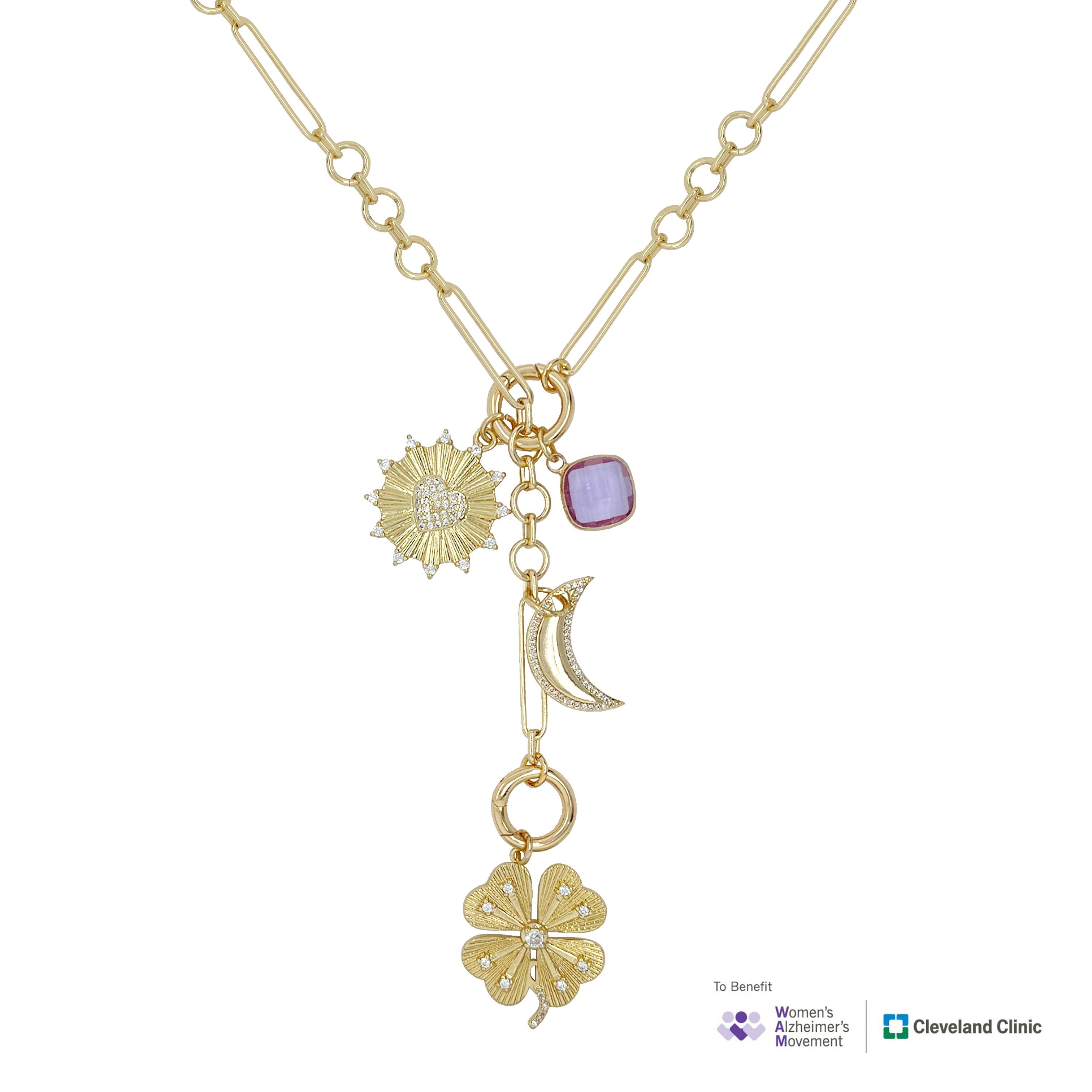 A gold-toned necklace with multiple charms, including a sunburst, a lavender square stone, a crescent moon, and a four-leaf clover, shown on a white background with To-Benefit Women's Alzheimer's Movement and Cleveland Clinic logos at the bottom right.
