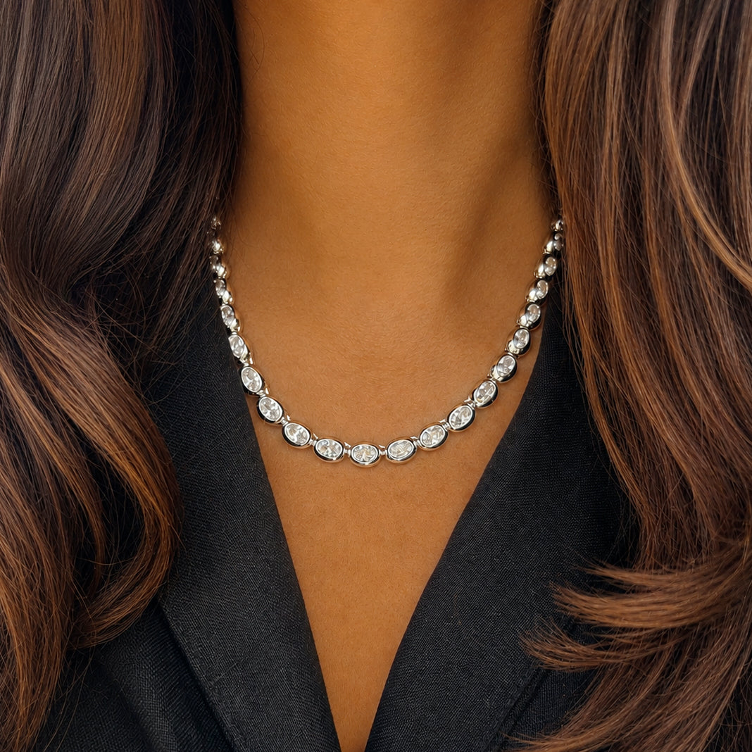 Oval Bezel Set Tennis Necklace
Timeless sparkle meets modern elegance in this stunning necklace. Featuring oval-cut cubic zirconia stones set in sleek white gold-plated bezel settings, this refined piece offers a sophisticated interpretation of a classic tennis silhouette. Perfect for stacking with delicate chains or wearing solo as an everyday signature piece.
White Gold Plated
Cubic Zirconia
16" Length