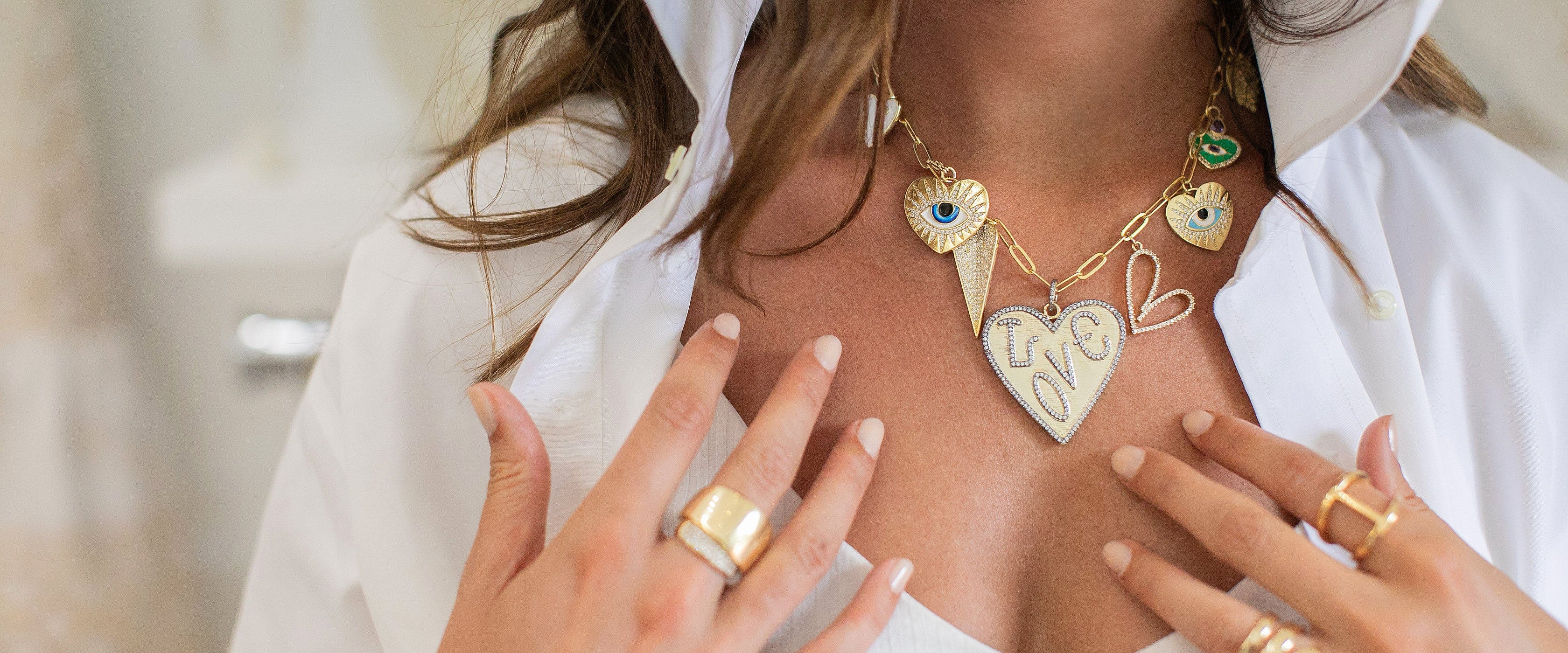 Charm necklace and rings on a person.