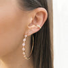 Pave circle hoop earrings on woman's ear, worn with pave ear cuff and diamond stud