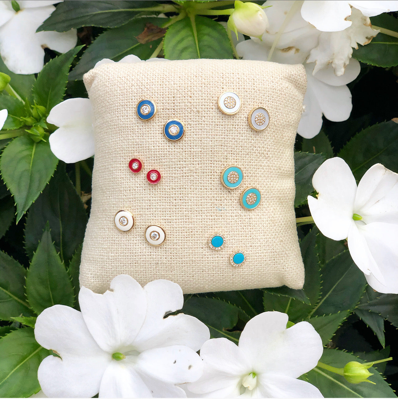 Diamond + turquoise circle earrings on display pillow with different colored diamond circle earrings