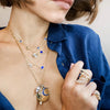 Diamond evil eye necklace layered with others from yellow gold chain link necklace collection on woman's neck
