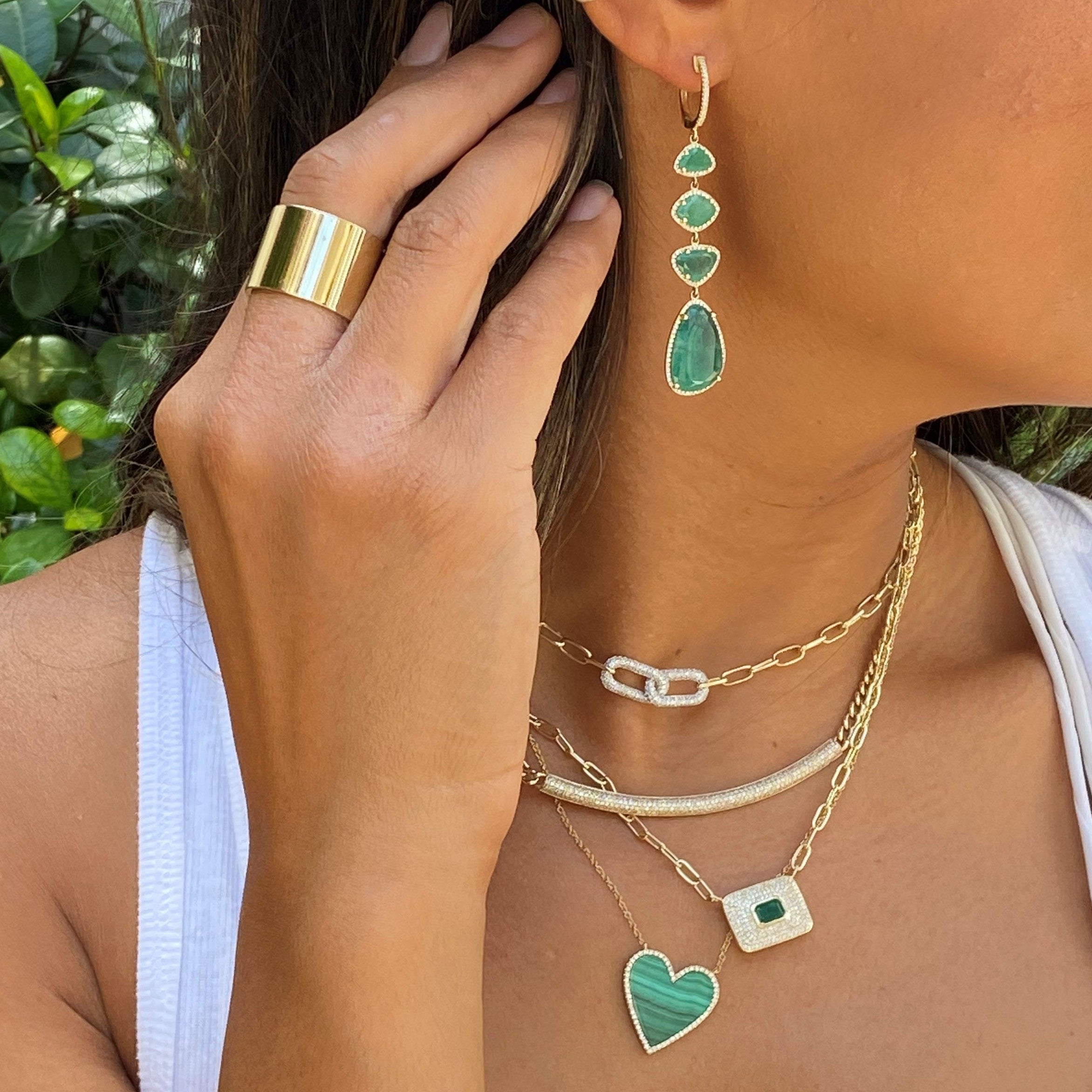 Emerald & diamond earrings worn with layered corresponding yellow gold and green accented jewelry