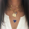 Multi charm necklace worn layered with yellow gold chains