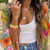 Woman wearing wide band ring with colorful jewelry and outfit