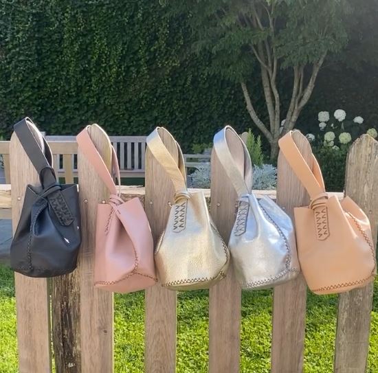 Light Gold Leather Mini Bucket Bag 6.3" X 5.5" X 5.5" Up-cycled Leather Hand stitched As each bag uses up-cycled leather and is hand-stitched, each bag is unique & no two are alike. The item will vary, available in neutral pastel colors