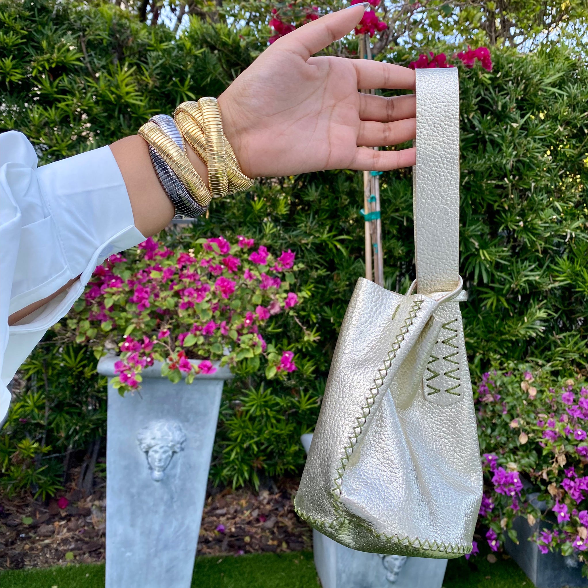 Light Gold Leather Mini Bucket Bag 6.3" X 5.5" X 5.5" Up-cycled Leather Hand stitched As each bag uses up-cycled leather and is hand-stitched, each bag is unique & no two are alike. The item will vary