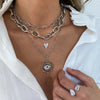 Chunky and dainty white gold layered necklace look.