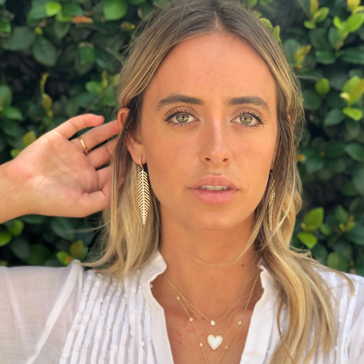 Women wearing Pave Diamond Feather Drop Pierced Earrings • 14K Yellow & White Gold • 2.75" L X .5" W • Diamond 1.29CT