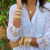 Woman wearing triple strand bracelets in rose, yellow, and white gold, with engravable heart necklace