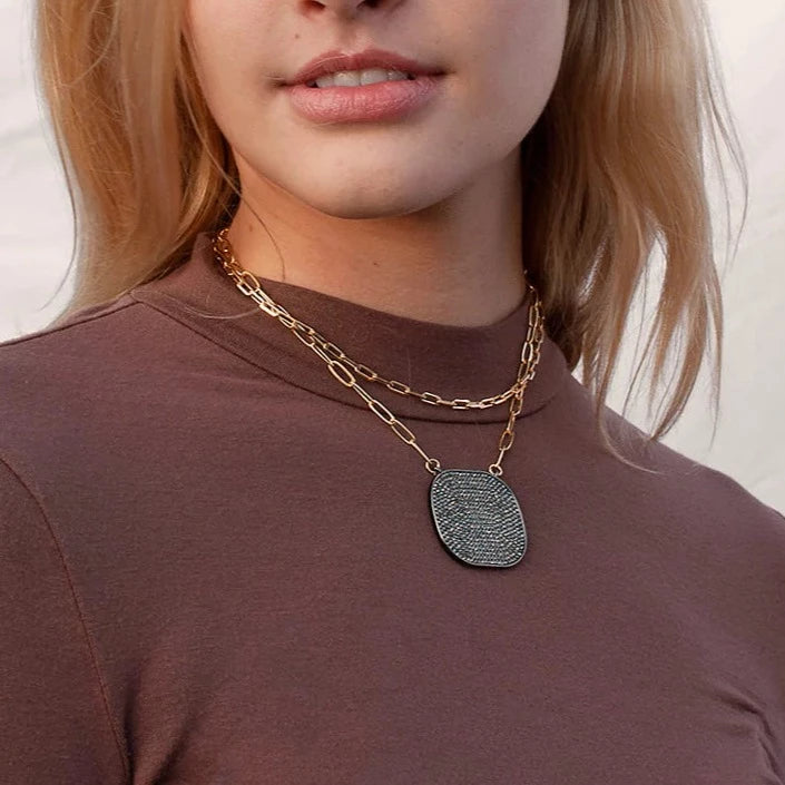 Pave Black CZ Plate Pendant Statement Link Chain Necklace The black CZ stones on the pendant are set in a pave style, creating a unique look that exudes confidence and style. The pendant hangs gracefully from the link chain, adding a touch of sophistication to your look. Make a bold statement with this edgy and chic pendant necklace! Yellow Gold Plated 1.32" Long X 1.52" Wide 16.5" Long