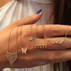 Woman's hand holding diamond butterflies necklace with similar rose gold & diamond pave necklaces to be worn together