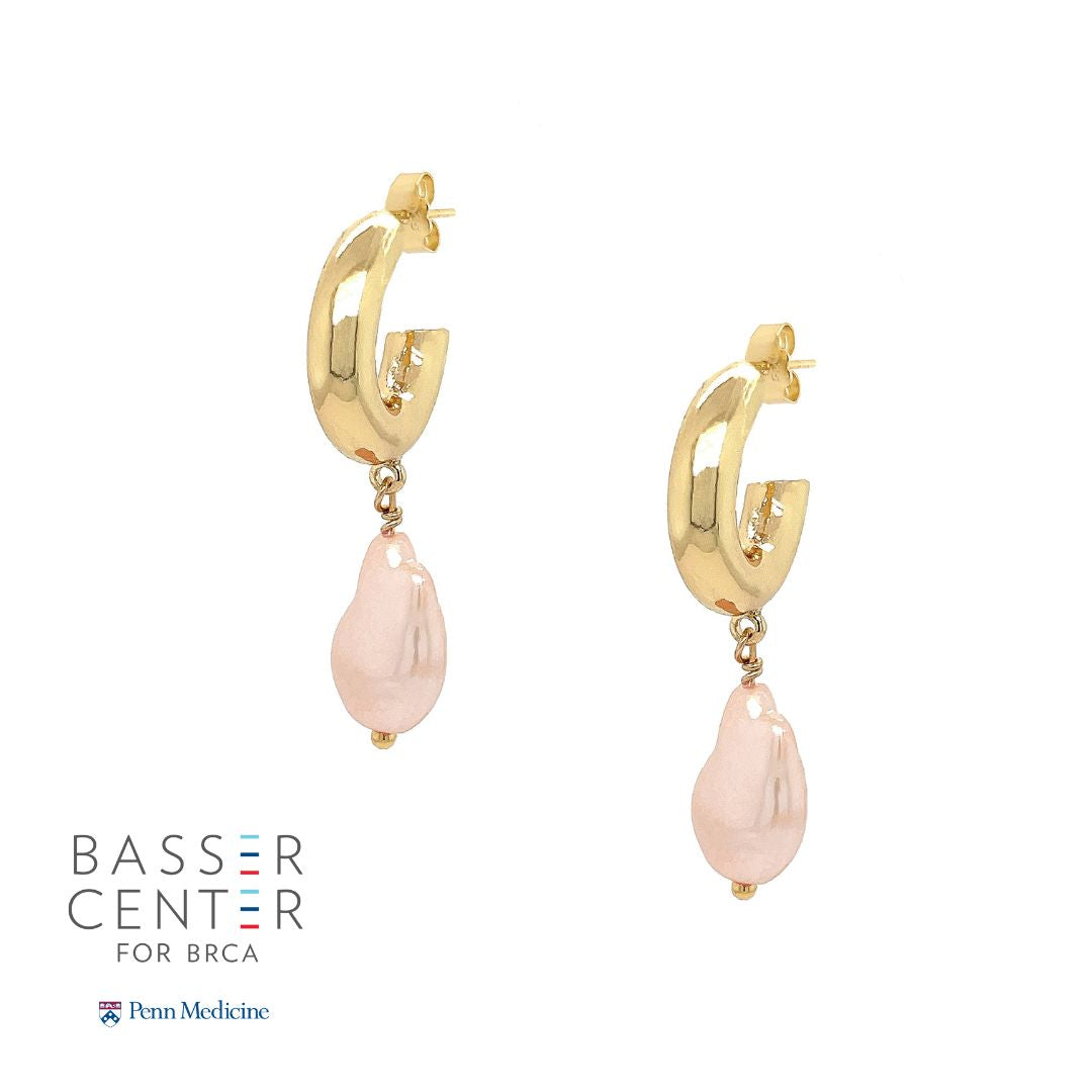 These exquisite hoops feature a stunning light pink pearl elegantly set in your choice of yellow or white gold plating, embodying the essence of elegance and hope. These gorgeous earrings perfectly complement any ensemble, making them a versatile addition to your jewelry collection. Pair them effortlessly with other jewels and stay in vogue while making a meaningful impact.   Pink Pearl Drop on Small Hoop Pieced Earrings  Yellow or White Gold Plating