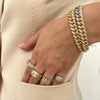 Diamond link statement bracelet worn with yellow and white gold rings.
