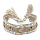 Beige bracelet with star charms and tassels on a white background