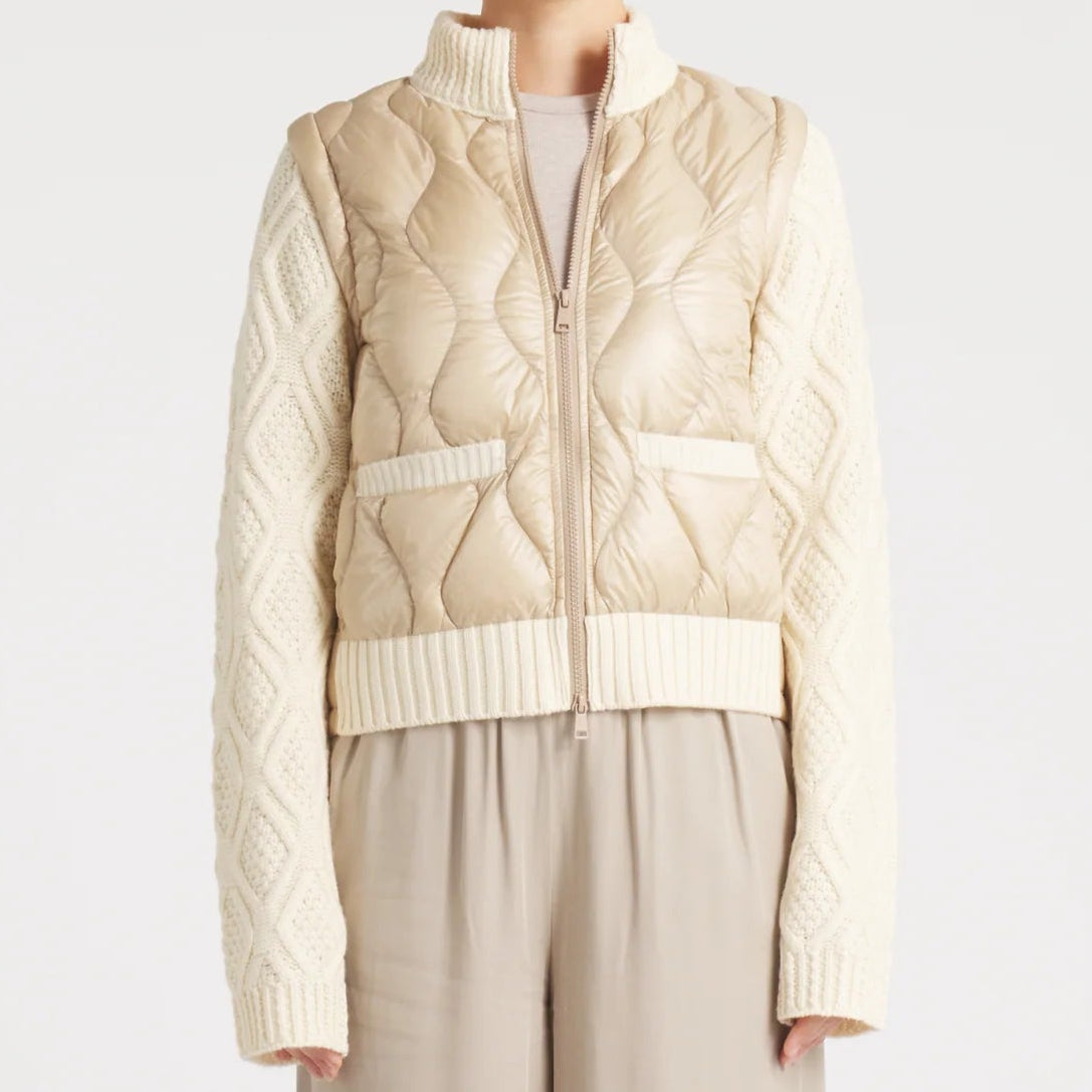 Woman wearing a beige knitted vest over a sweater with matching pants on a white background