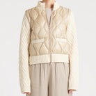 Woman wearing a beige knitted vest over a sweater with matching pants on a white background