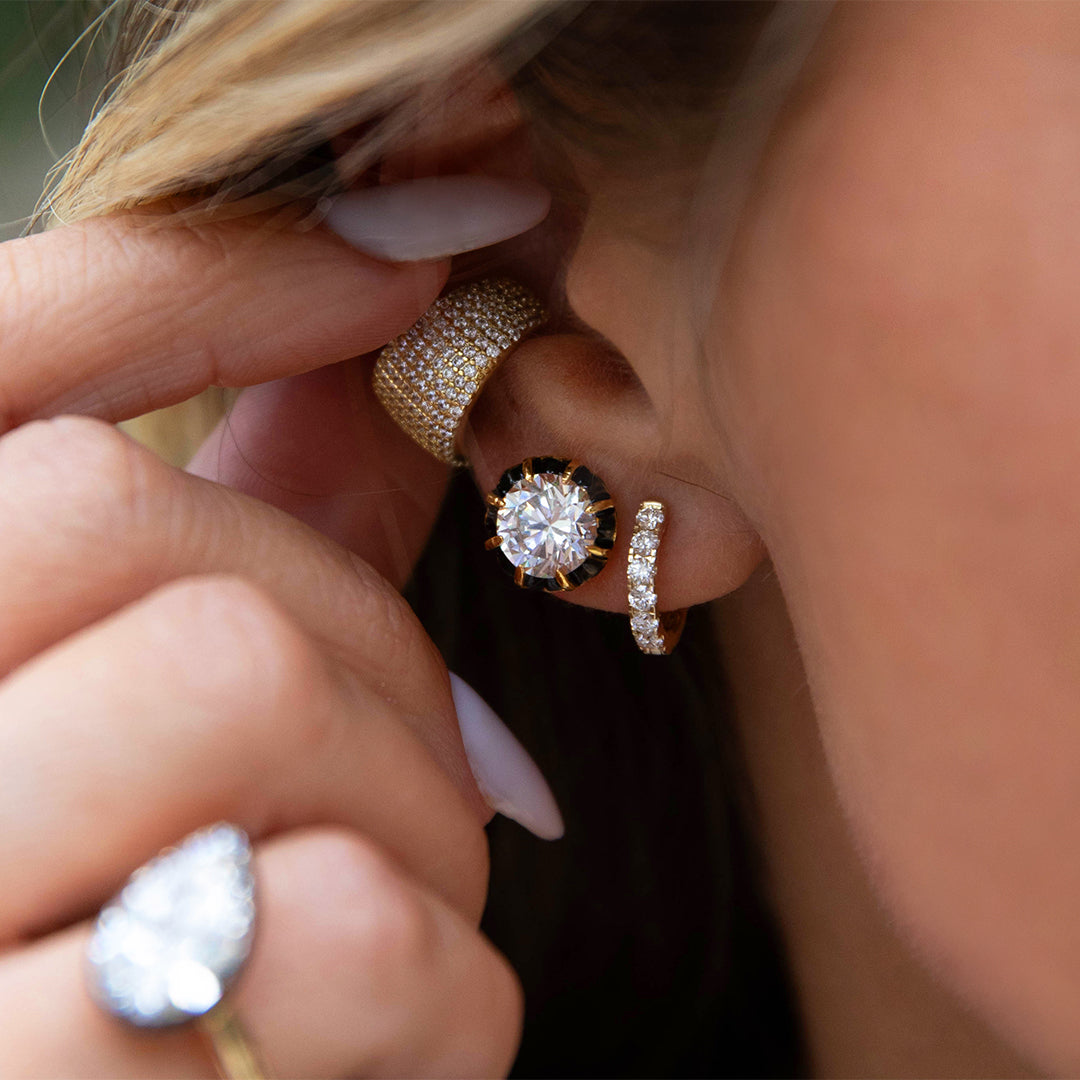 Close-up of a person wearing multiple diamond earrings 