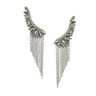 Pair of silver wing-shaped earrings with chain fringes on a white background