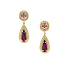 Gold earrings with pink and red gemstones on a white background