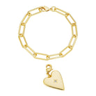 Gold chain bracelet with a heart-shaped charm on a white background