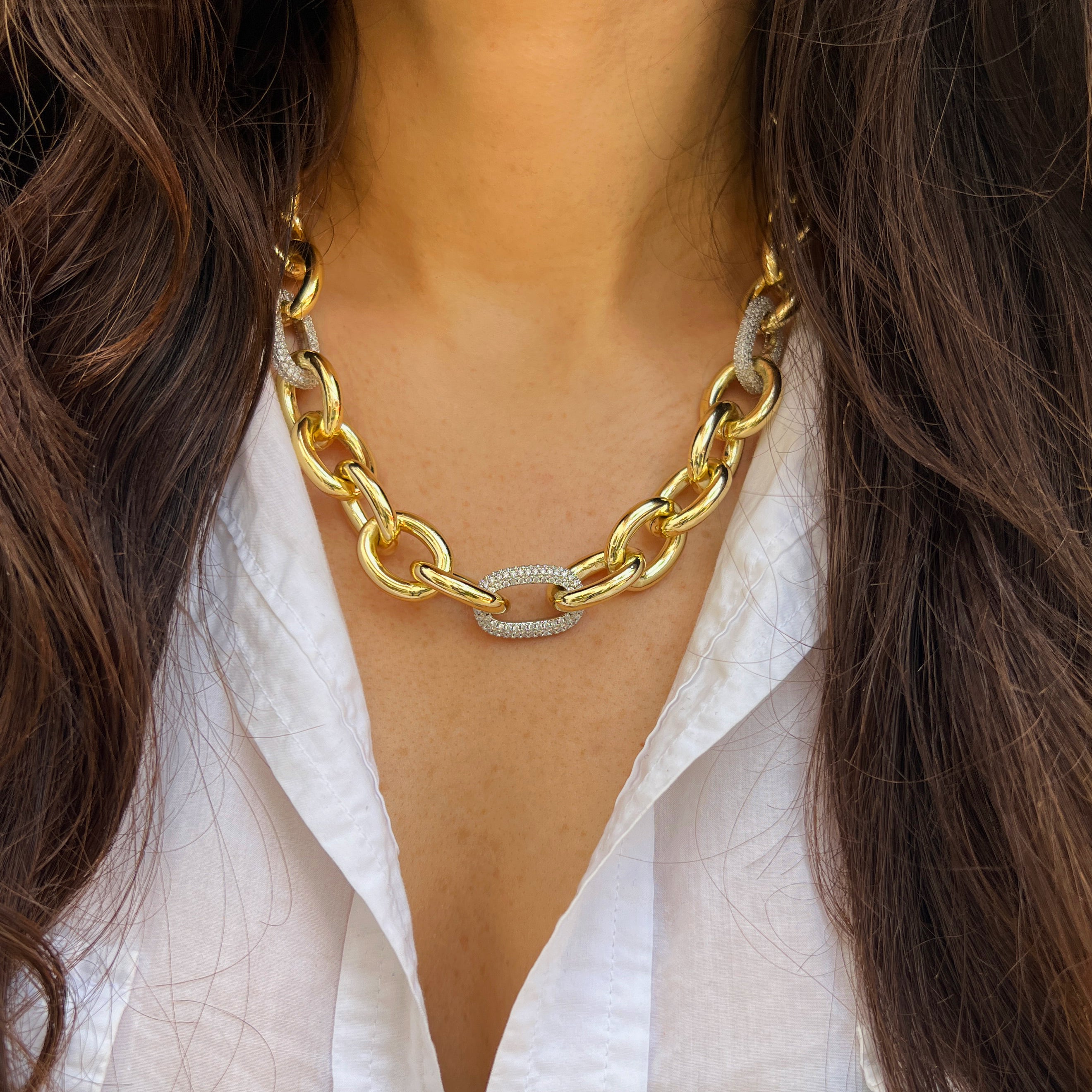 Gold chain necklace worn by a person with long dark hair and a white shirt.

Pave CZ Two Tone Link Chunky Chain Necklace

Yellow Gold Plated
Links: 0.8" Long X 0.65" Wide
18-19.5" Long