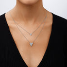 Two heart-shaped silver necklaces on a person wearing a black top.

Layered Double Heart Necklace

White Gold Plated
Small Heart: 0.38" Long X 0.38" Wide
Large Heart: 0.50" Long X 0.63" Wide
16-20" Long
Faux Pave Diamond
