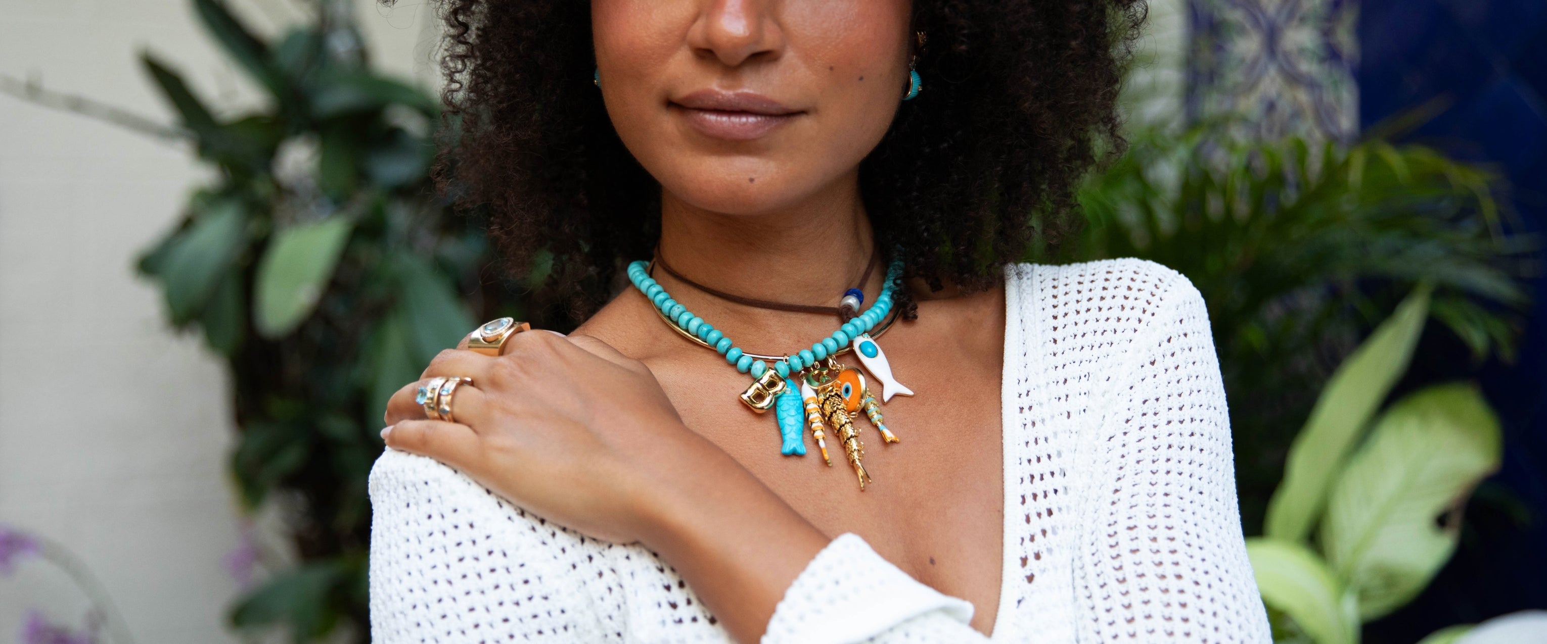 Woman wearing a turquoise necklace and fish charms