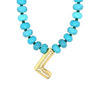 Turquoise beaded necklace with a gold clasp on a white background
