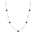 Necklace with heart-shaped blue stones on a gold chain against a white background