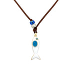 Necklace with a white fish pendant on a brown cord against a white background