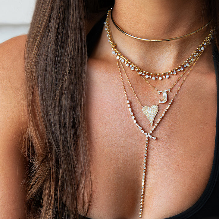 Close-up of layered necklaces with a cityscape background