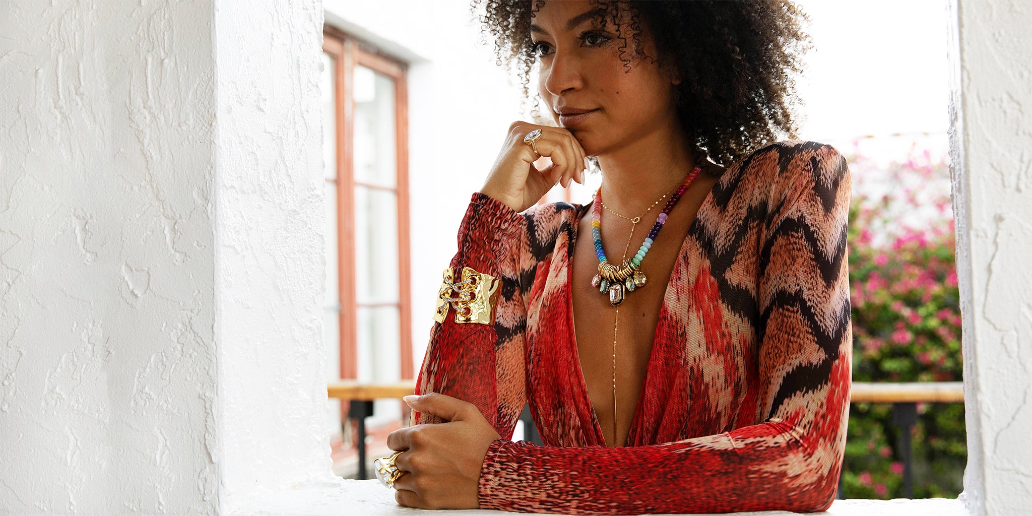 Woman wearing a colorful patterned top and jewelry