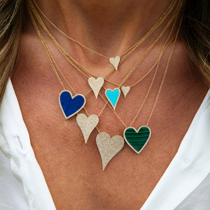 Necklace with colorful heart-shaped pendants on a person wearing a white shirt.