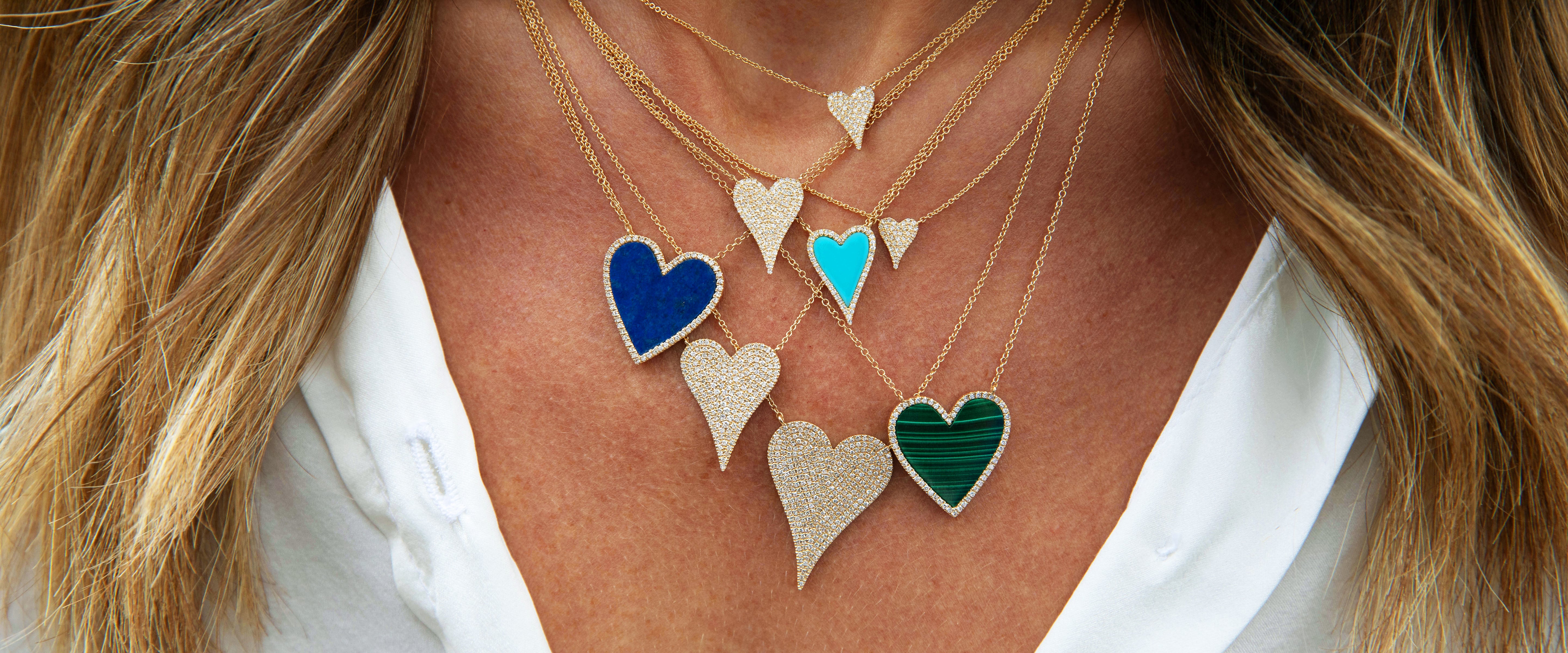 Necklace with colorful heart-shaped pendants on a person wearing a white shirt.