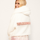 The Warrior Cropped Lounger is more than loungewear—it’s a lifestyle. I designed it in plush sherpa to be worn 24/7, 365 days a year, from couchside to courtside and everywhere in between. For me, it’s a true badge of comfort and strength—there for every moment I choose to thrive.&nbsp;Show here in White.


Product Details &amp; Care Instructions:

Fabrication: 100% Polyester, Sherpa
Features: Sherpa, Hood, Button Front-Closure, Rib Cuffs with Thumbholes
Fit: Relaxed Fit: Generously Cut with Maximum Wearing