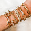 Diamond link statement bracelet worn with yellow gold pave chain link bracelets