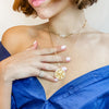 Woman wearing diamond coil ring with yellow gold choker and pendant necklaces