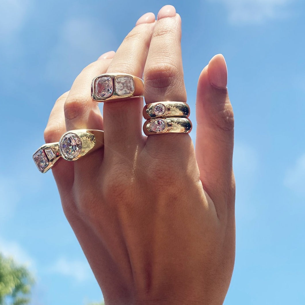 Emerald cut ring worn with others in yellow gold gypsy ring collection