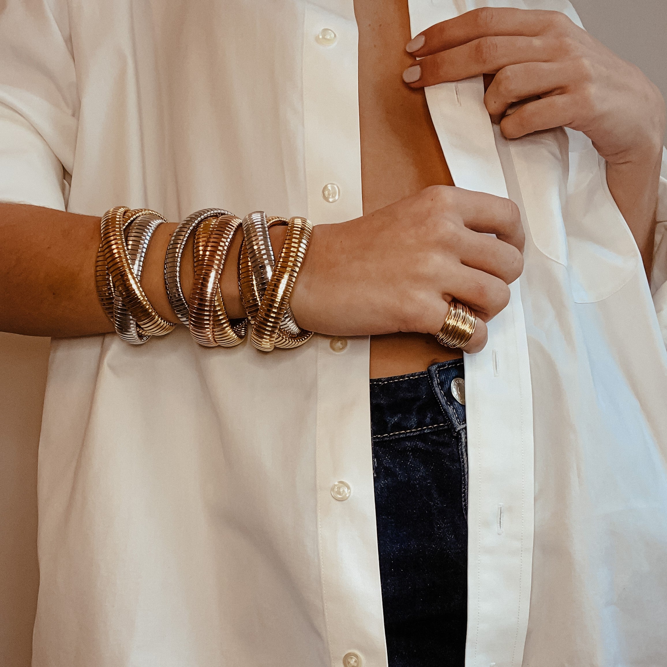 Woman wearing cluster ring with classic triple strand bracelets
