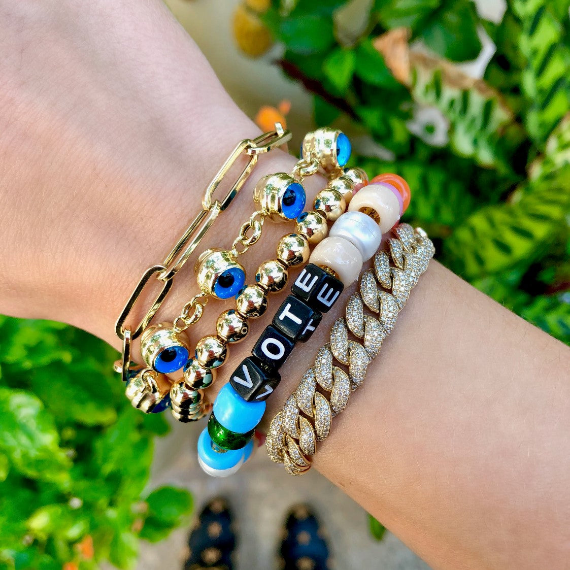 Eye chain bracelet worn with yellow gold beaded and pave bracelets