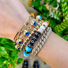 Eye chain bracelet worn with yellow gold beaded and pave bracelets
