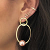 Woman wearing pave ear cuff with diamond crawler earring and open pearl hoops