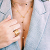 Woman wearing yellow gold cluster ring with star necklaces
