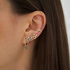 Emerald & Diamond huggies on woman's ear with other yellow gold & emerald earrings