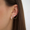 Diamond earrings on a woman's ear.