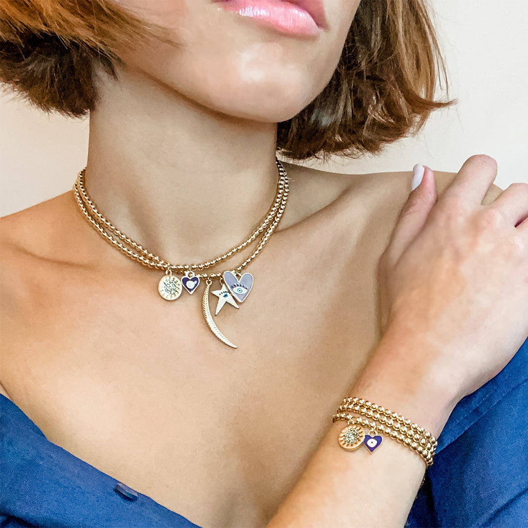 Multi charm bead necklace worn as both a bracelet and a necklace, as shown by one model