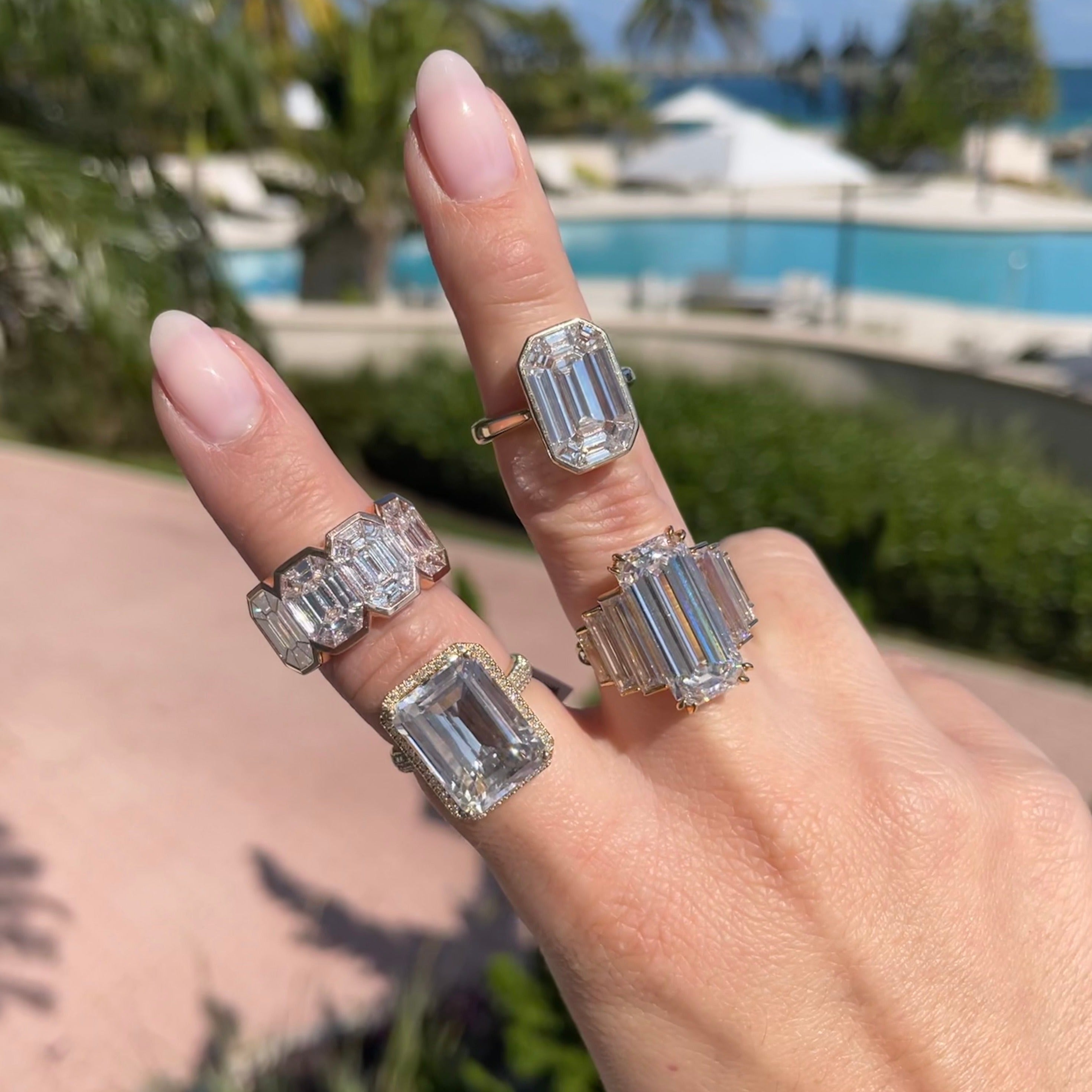 Woman wearing diamond emerald cut rings.